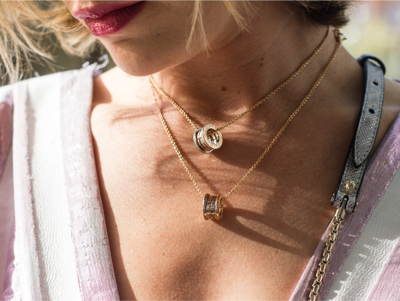 close-up of woman's neck with two gold necklaces